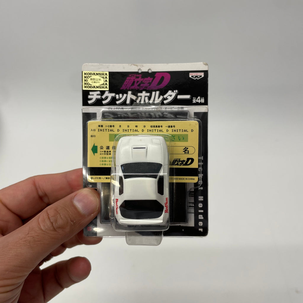 Model car in packaging held by a hand on a gray background