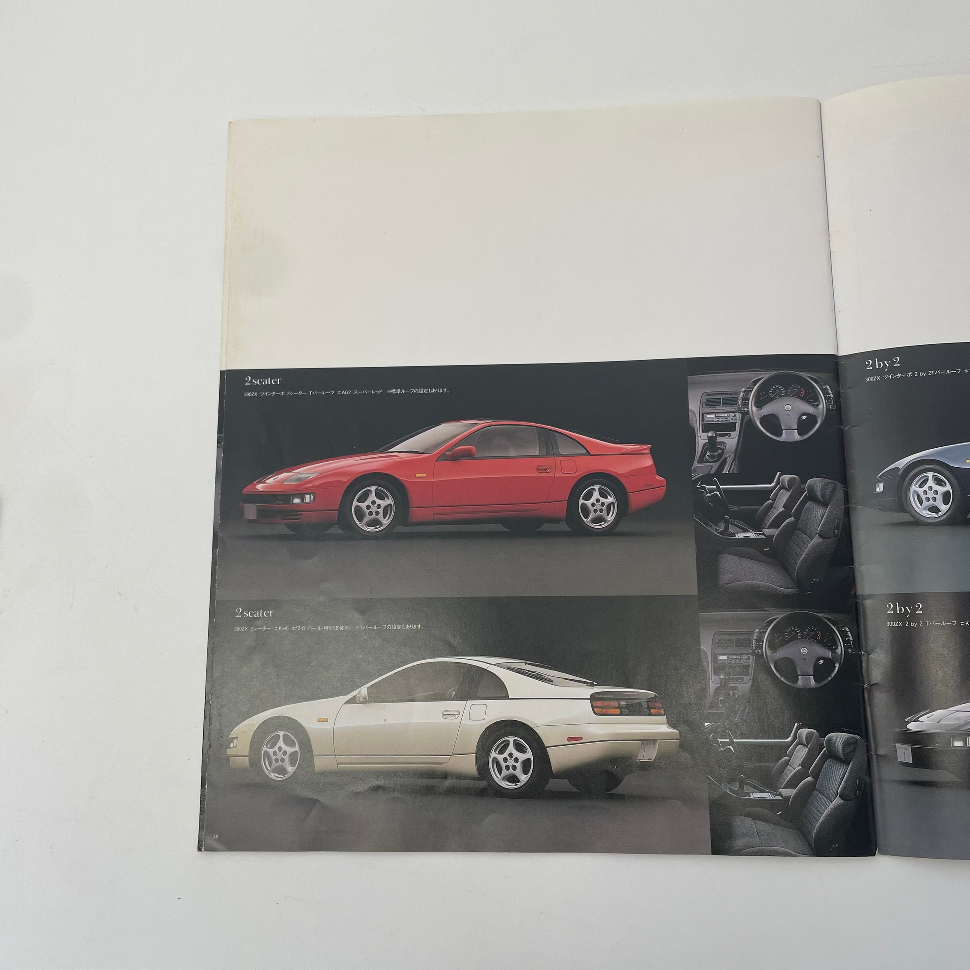 Poster of two cars, one red and one white, on a black background.
