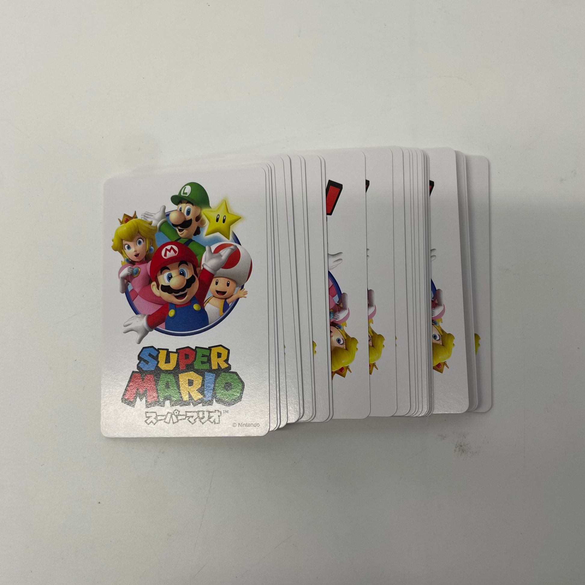 Stack of Super Mario-themed playing cards on a white background