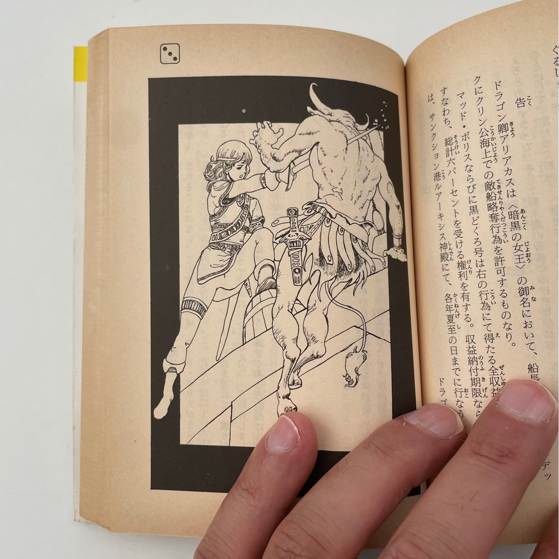 Open book with a illustration of a person riding a bull, held by a hand on a white background