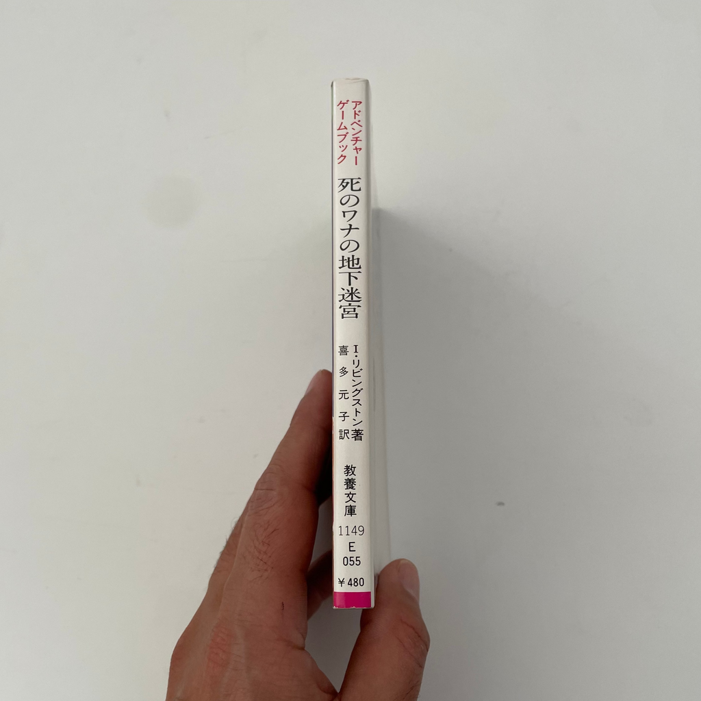 Hand holding a cylindrical tube with text on a plain background