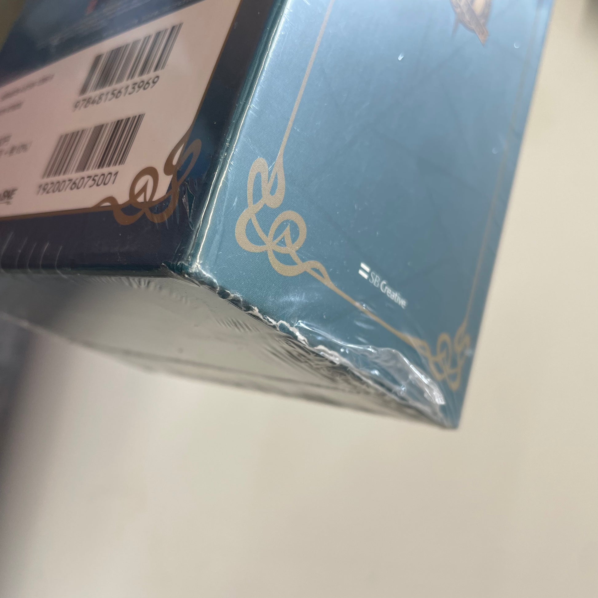 Close-up of a blue product packaging with gold accents on a white surface