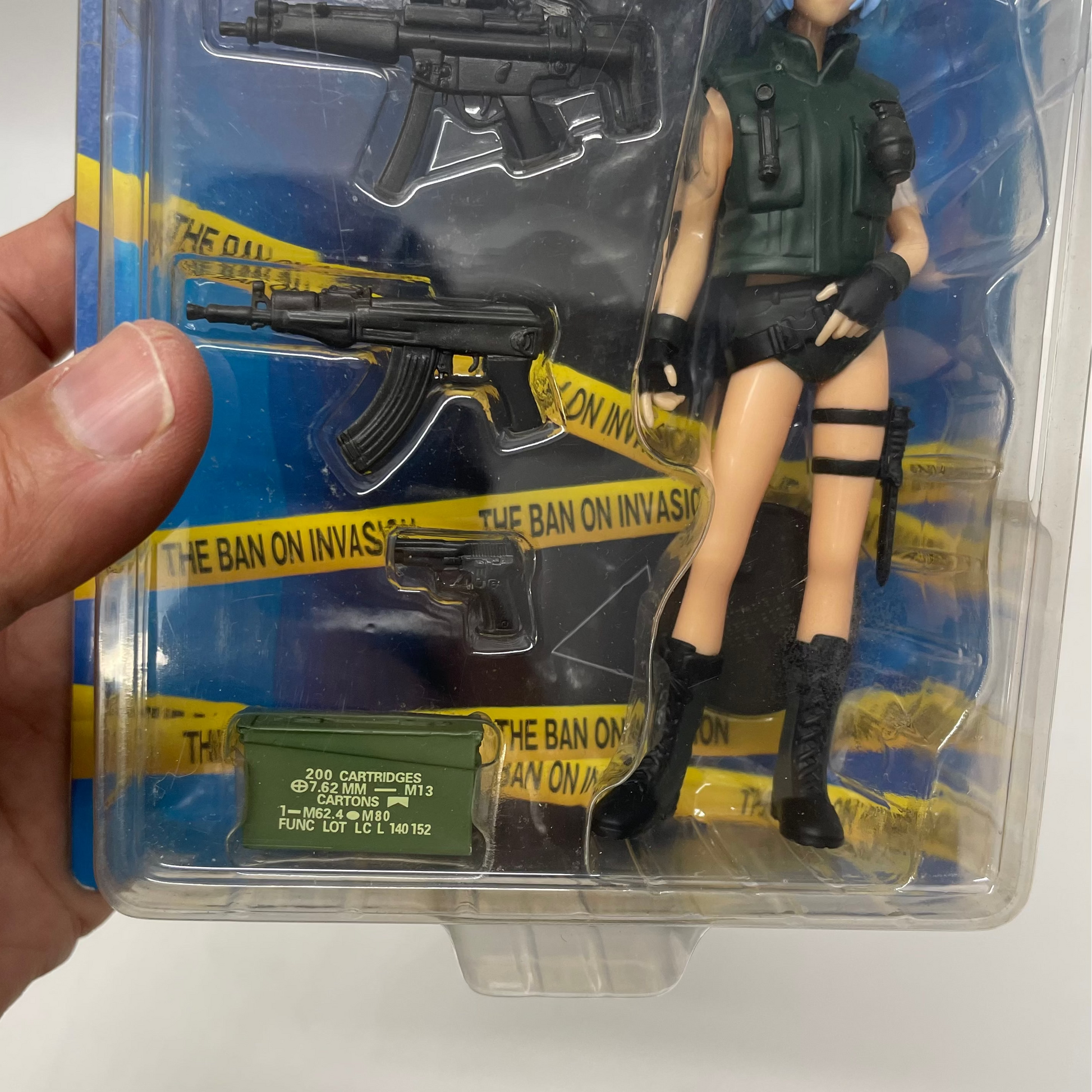 Toy figure in packaging with weapon and tactical gear on a white background