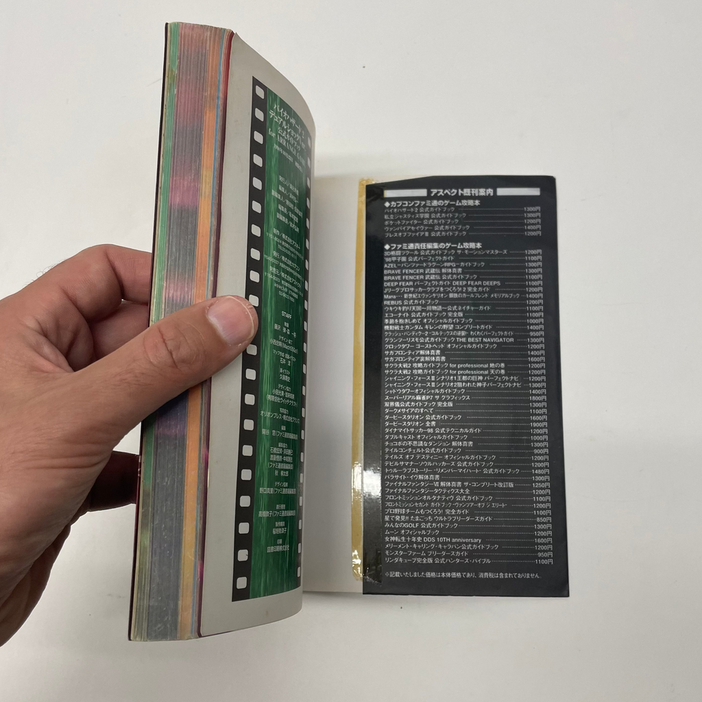 Hand holding a book with a unique design on a white background