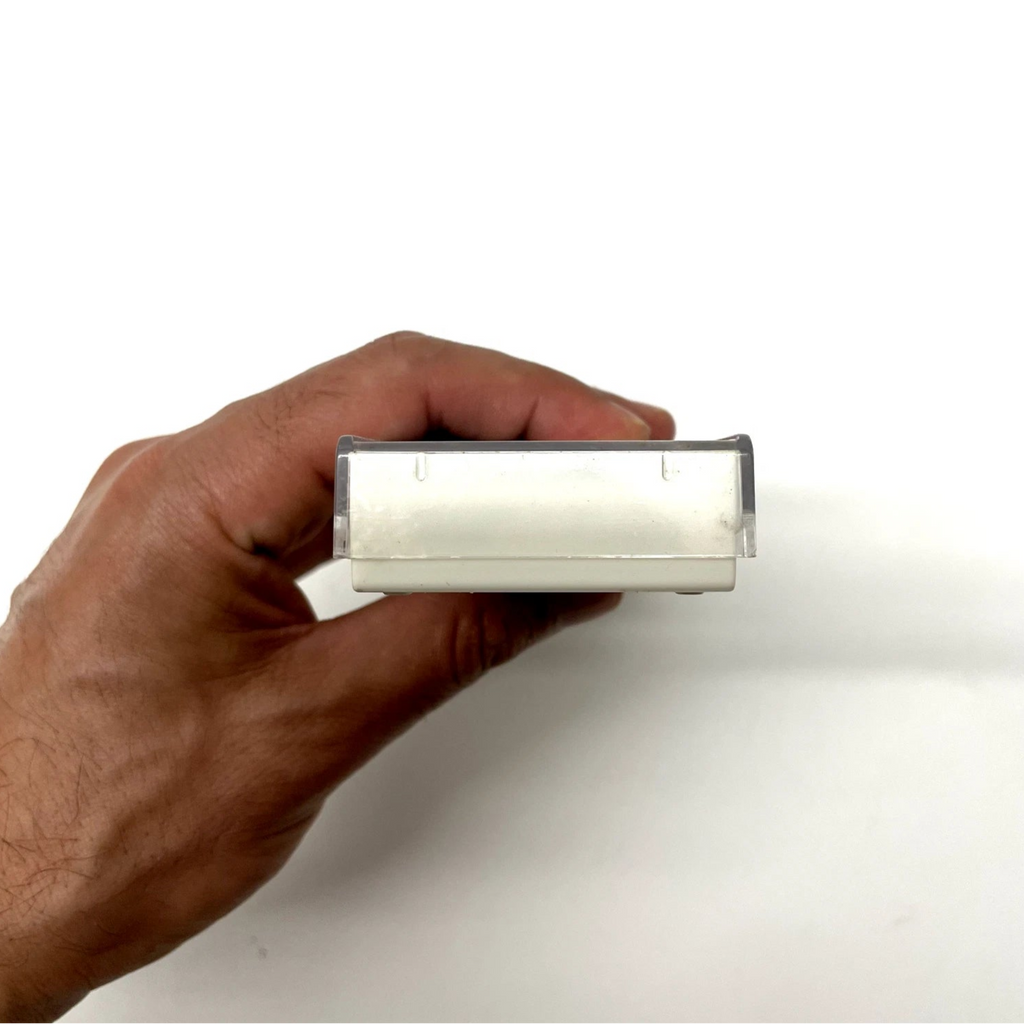Hand holding a rectangular object against a white background