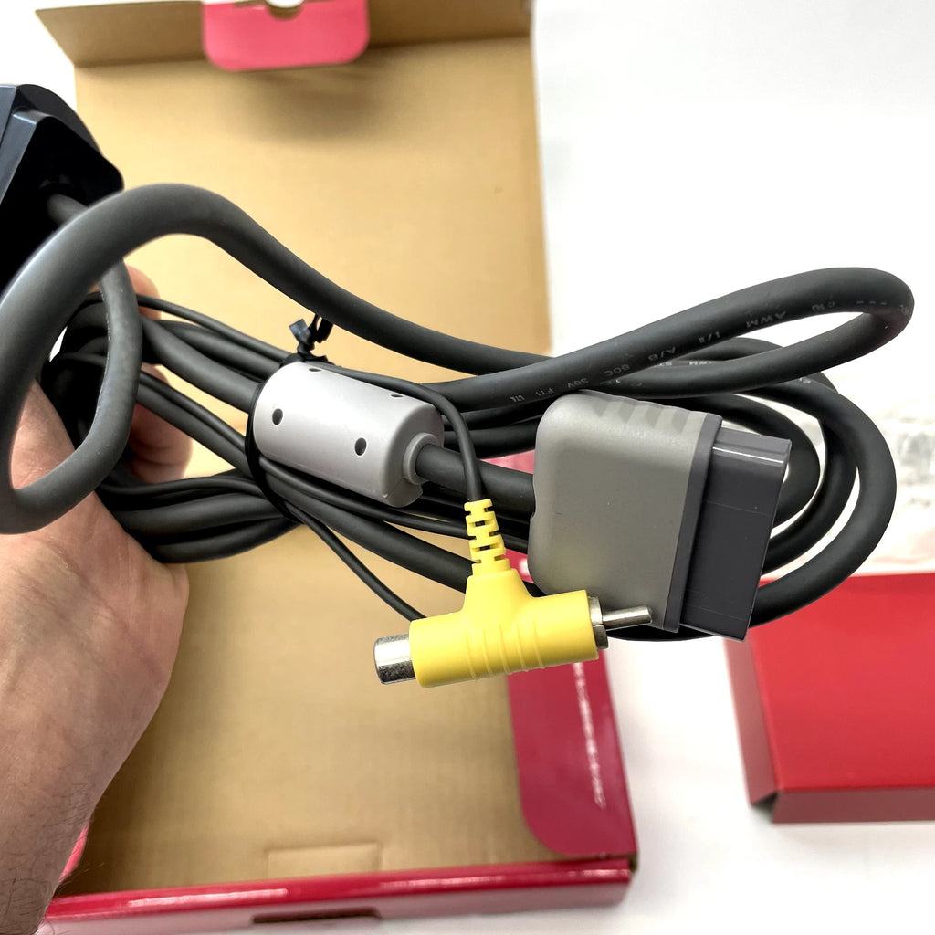 Cable with a yellow connector held by a hand against a white background