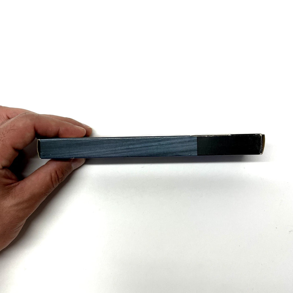 Hand holding a rectangular object with a blue and black design on a white background