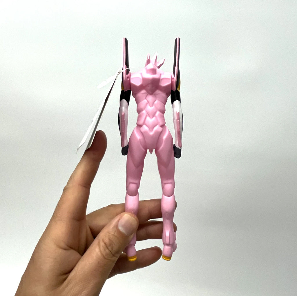 Hand holding a pink and black action figure against a white background