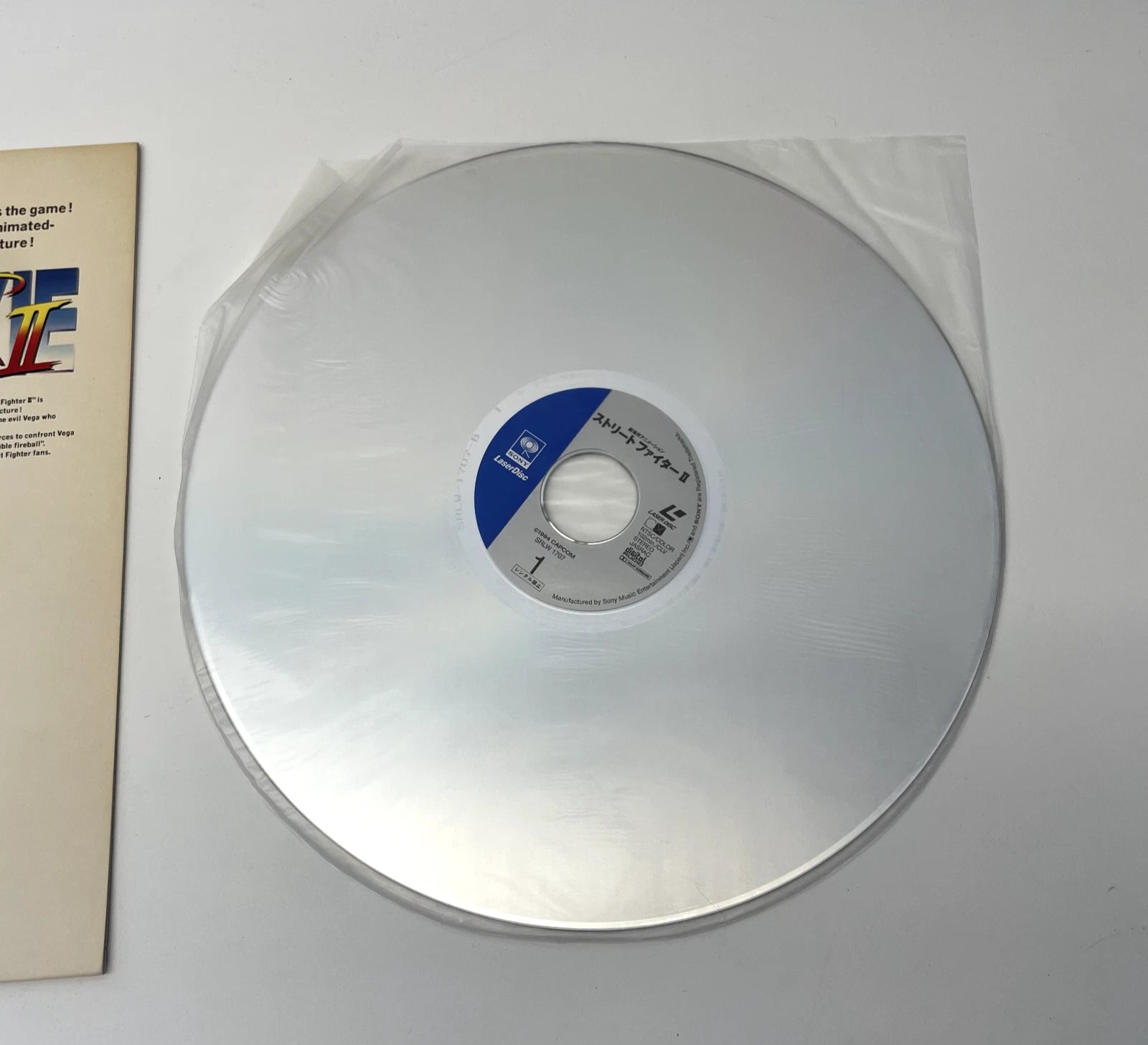 Clear vinyl record with a blue label on a white background